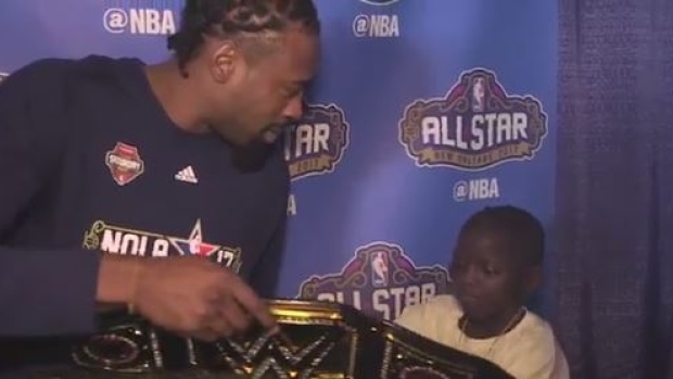 DeAndre Jordan autographs Jarrius "J.J." Robertson's WWE belt during NBA All-Star Weekend.