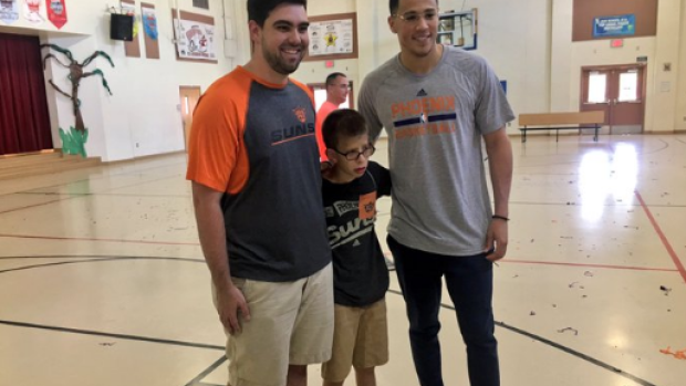 Devin Booker poses with Special Olympian Noah Smith and his brother Brad.