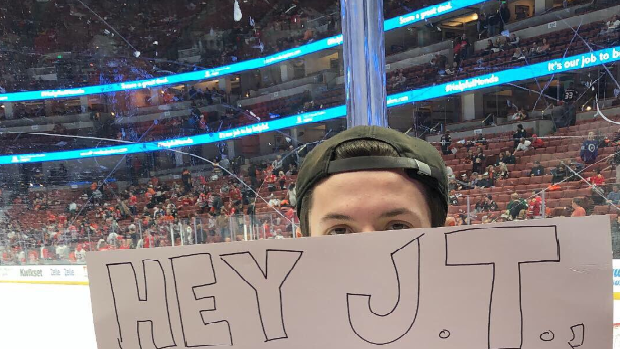 A fan holds a Fortnite sign at the Honda Centre during the Ducks vs. Blackhawks game.