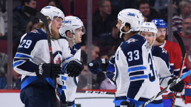 Winnipeg Jets players celebrate after scoring a goal against the Montreal Canadiens.