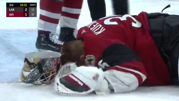 Darcy Kuemper lays on the ice after taking a stick blade to the eye.