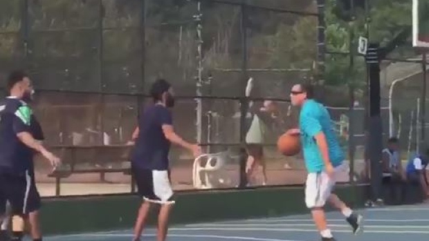 Adam Sandler participating in a pickup basketball game.